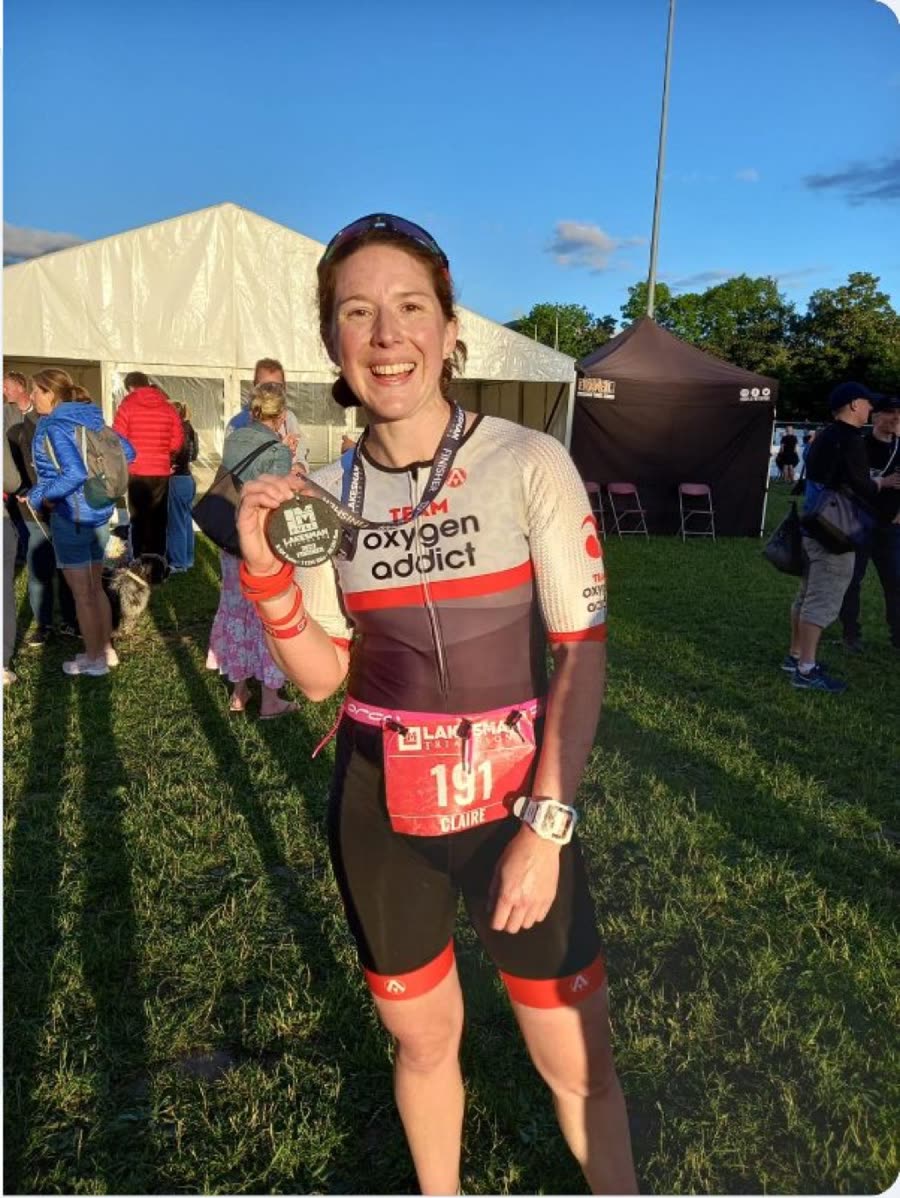 Claire with her medal at the Lakesman in Team Oxygenaddict kit