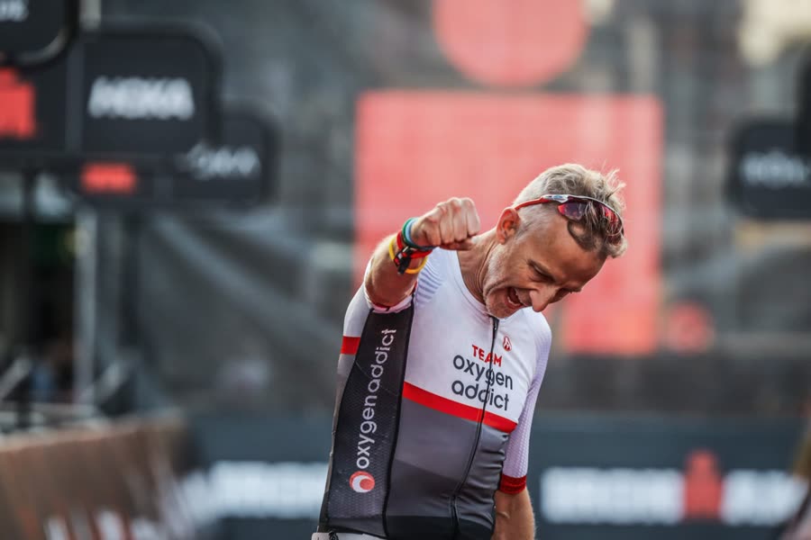 Steve punching the air at the IRONMAN UK finish in Team Oxygenaddict kit