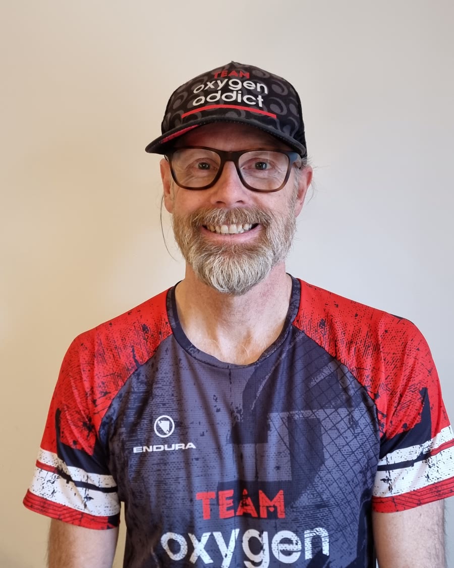 Coach Rob Wilby smiling, in his Team Oxygenaddict cap and kit